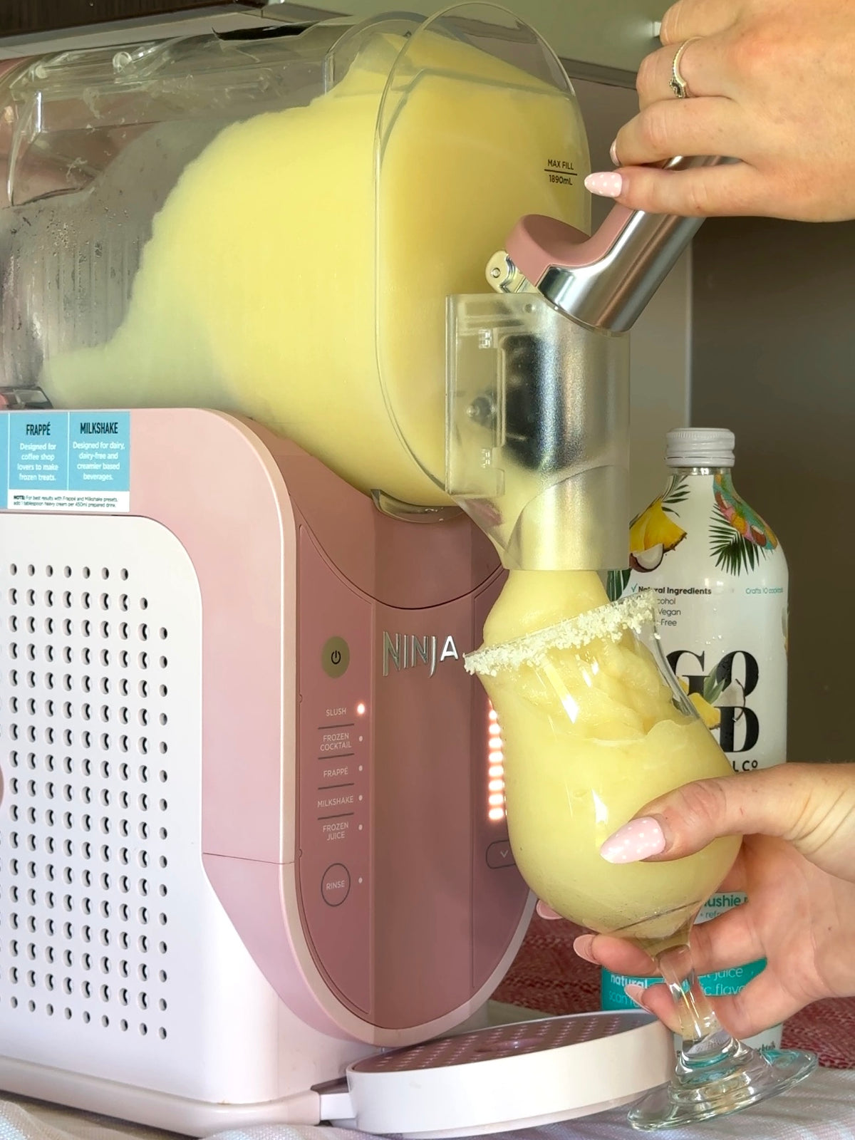 Pouring a Piña Colada slushie in a glass. Ninja