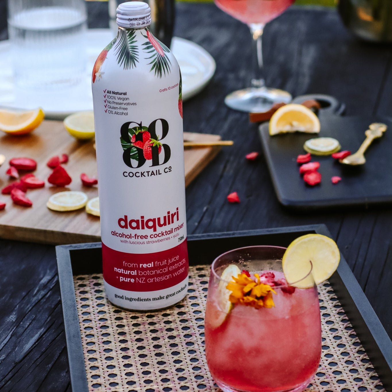 Image of cocktail in glass next to Daiquiri cocktail mixer in bottle