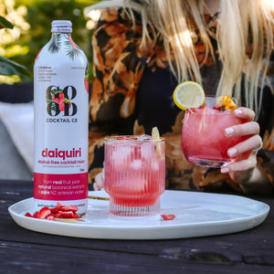 Daiquiri cocktail mixer in bottle with two made cocktails in glasses