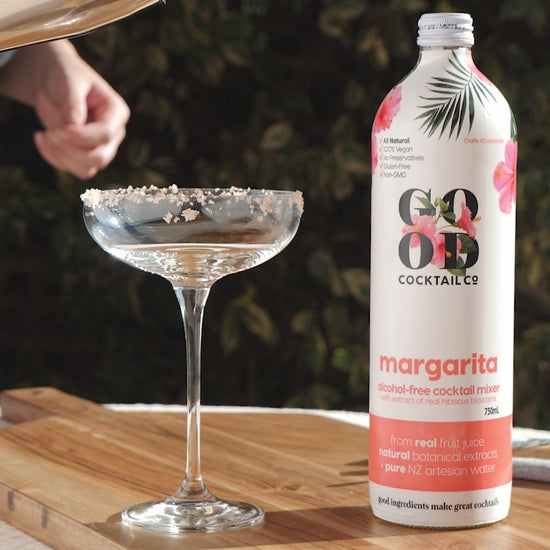 Margarita cocktail mixer next to empty cocktail glass