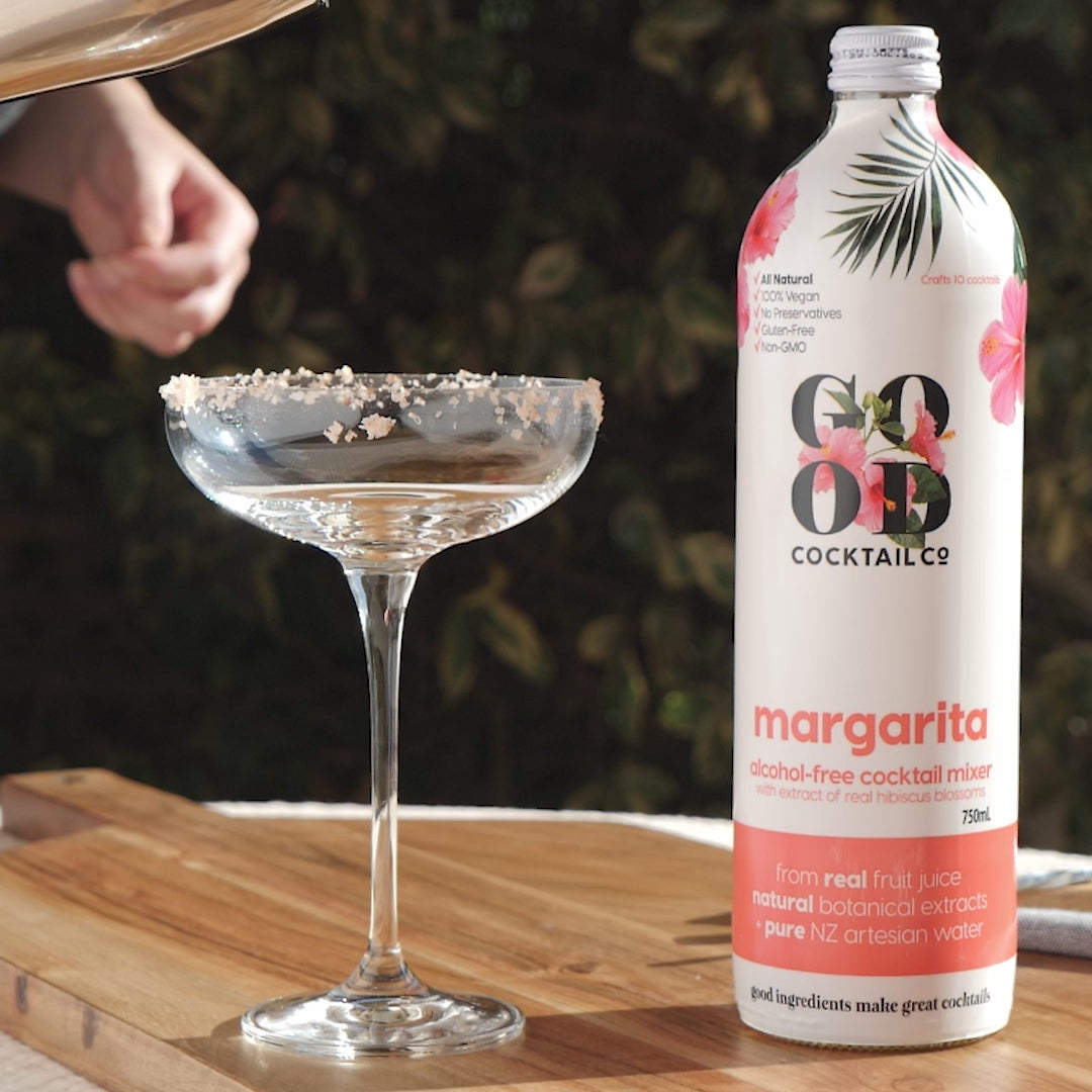 Margarita cocktail mixer next to empty cocktail glass