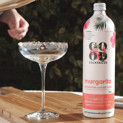 Margarita cocktail mixer next to empty cocktail glass
